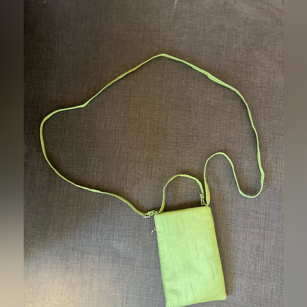 This is a small green crossbody bag with an extra strap to adjust the length